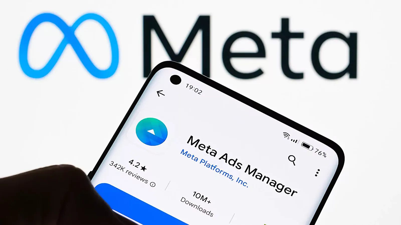 The Meta Ads Manager app open on a phone in front of the Meta logo